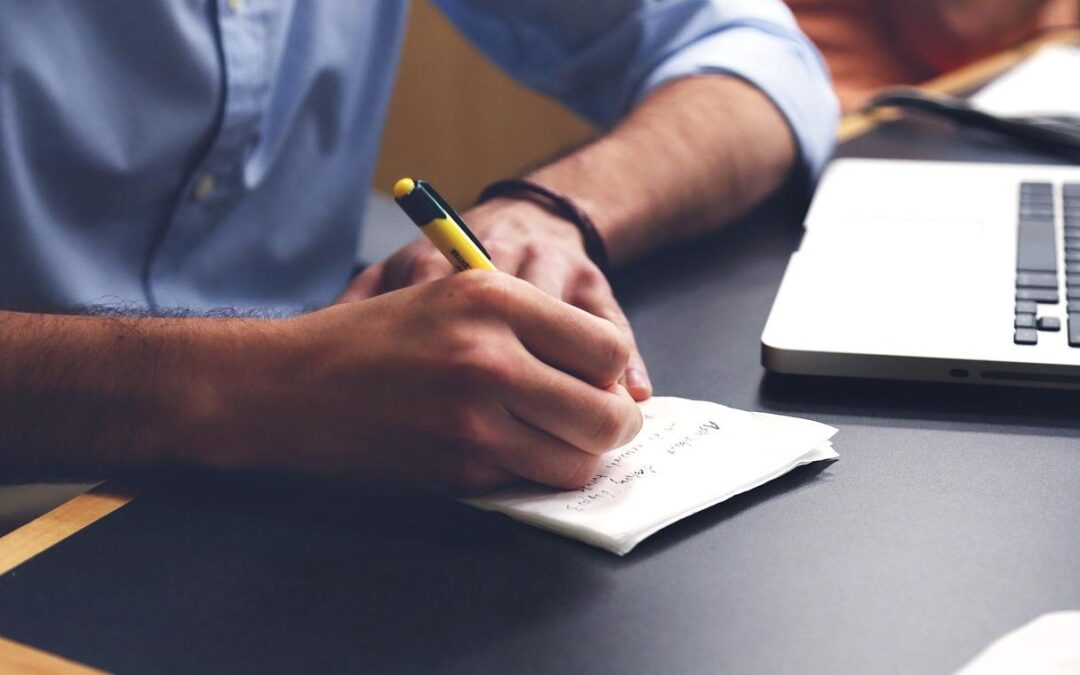 person writing with a pen on paper